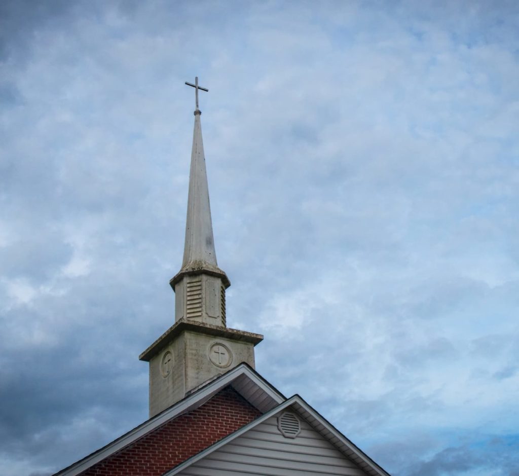Church steeple against a cloudy sky.