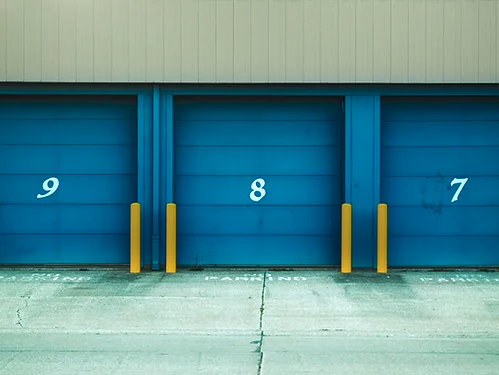 Blue garage door with a number 8 painted on it in white.